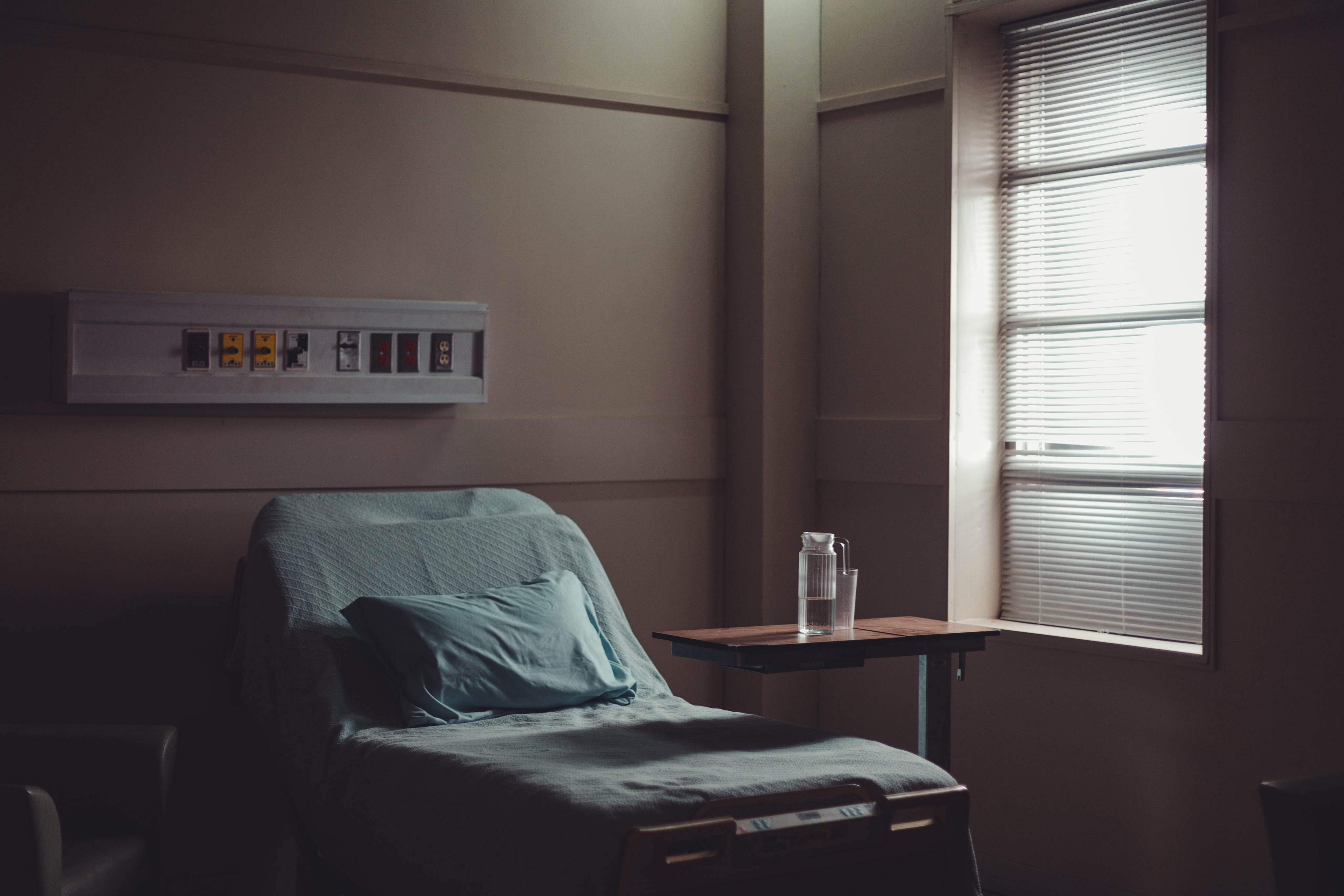 a-water-jug-and-glass-on-a-table-by-a-hospital-bed.jpg